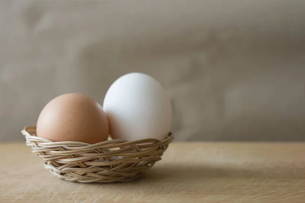 Белые Коричневые Яйца Лежат Маленькой Плетеной Корзине Деревянном Столе — стоковое фото