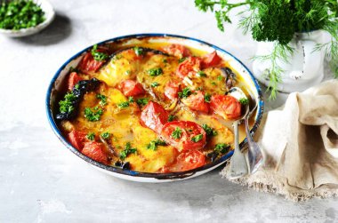 Fırınlanmış balık (köpekbalığı) domates ve baharatlarla gri arka planda pişirme kabında, durgun yaşam