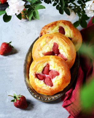 Süzme peynirli ve çilekli ev yapımı çörekler (cheesecakes) gri arka planda, Rus mutfağında
