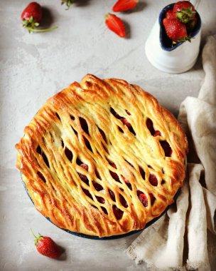 Gri bir arka planda fırında pişirilmiş lezzetli ev yapımı çilekli kek.