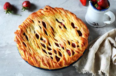 Gri bir arka planda fırında pişirilmiş lezzetli ev yapımı çilekli kek.