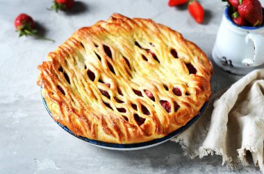 Gri bir arka planda fırında pişirilmiş lezzetli ev yapımı çilekli kek.