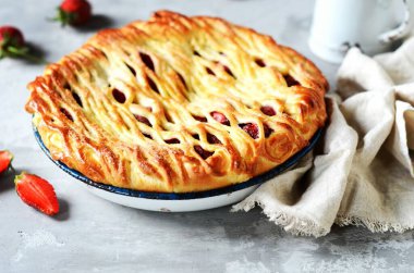 Gri bir arka planda fırında pişirilmiş lezzetli ev yapımı çilekli kek.