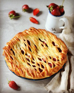 Gri bir arka planda fırında pişirilmiş lezzetli ev yapımı çilekli kek.