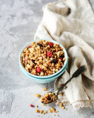 Böğürtlen ve fındıklı ev yapımı granola gri bir arka planda.