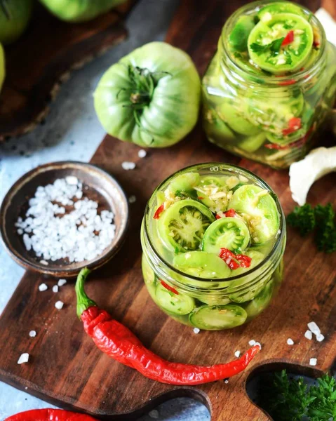 Fermented Pickled green tomatoes with horseradish and hot pepper on a gray background