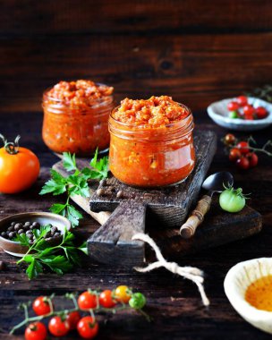 Koyu ahşap bir masada cam kavanozlarda sebzeli patlıcan havyarı.