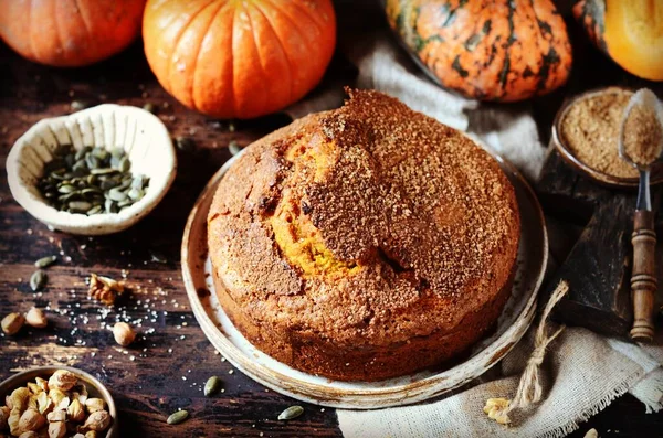 Pumpkin cake with brown sugar on a dark wooden background, still life