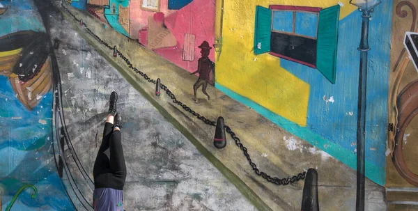 Renkli bir duvar yazısı ve ayakları havada bir kız. La Boca, Buenos Aires, Argntina 'da çekildi.