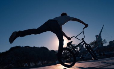 Bisikletçinin silueti bisiklet sürüyor.