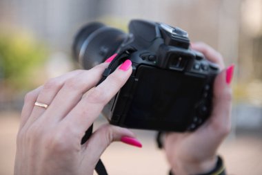 DSLR kamera tutan altın yüzüklü güzel bir kadın eli..