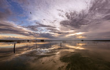 Pampaların sessiz gölünde gün batımı yansıması.
