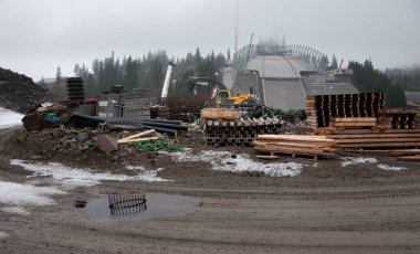 Oslo, Norveç - 1 Kasım 2009: Yeni Holmenkollen kayak pistinin inşaatı. İşçiler, çimento, borular, makineler, orman, hortumlar ve diğer elementler.