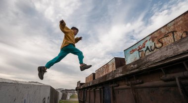 Buenos Aires, Arjantin - 9 Temmuz 2011: Çocuk La Boca mahallesindeki nehir kıyısının yanındaki tekneye atlayıp oynuyor.
