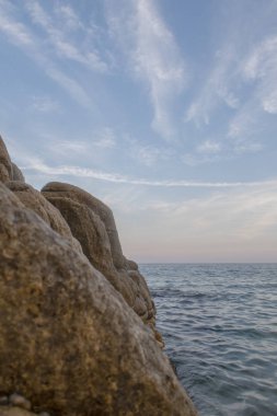 Costa Brava sahilde günbatımı. Pembe gökyüzü ve okyanus manzaralı. Platja d'aro, Catalonia.