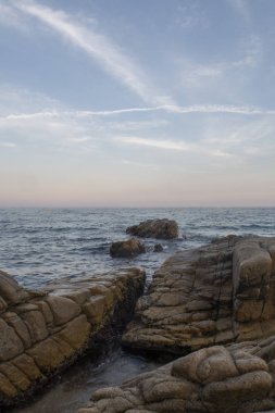Costa Brava sahilde günbatımı. Pembe gökyüzü ve okyanus manzaralı. Platja d'aro, Catalonia.