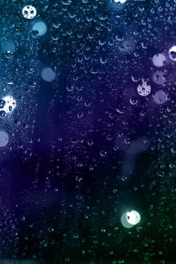 arka planını gece, cam arkasında renkli yağmur damlaları, şehir ışıkları bokeh.