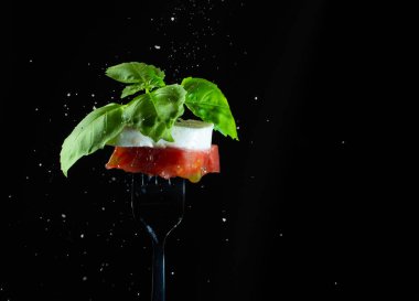 Taze fesleğenden yapılmış İtalyan bayrağı renkleri, koyu çatallı Mozzarella peyniri ve tuzlu taze domates. Yaklaş. Caprese salata malzemeleri..