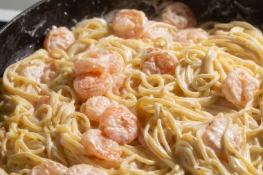 Kremalı ve sarımsaklı karidesli spagetti pişirme işlemi. Kapatın..