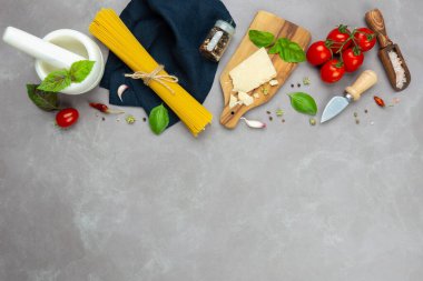 İtalyan makarnası için ham malzemeler: çiğ spagetti, taze domates, parmesan peyniri, deniz tuzu, kurutulmuş biber, taze fesleğen yaprağı ve sarımsak..