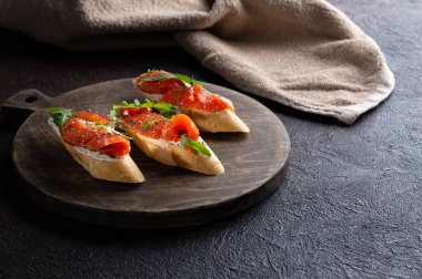 Somonlu ev yapımı bruschetta, vişneli domates, taze roka ve kurutulmuş biber..