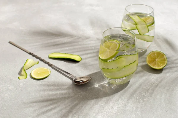 Verfrissende detox cocktail met komkommer en lims.Zomer cocktail met palmbladeren schaduw.Close-up van gezonde drank. — Stockfoto