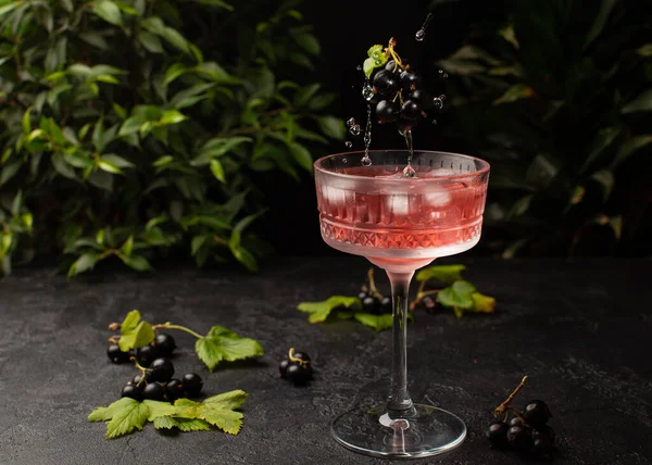 Cocktail di frutti di bosco freschi con ribes nero e ghiaccio in vetro cristallino.Colpo di bevanda in movimento freeze, gocce volanti e frutti di bosco.. — Foto Stock