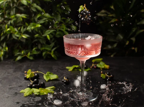 Cocktail di frutti di bosco freschi con ribes nero e ghiaccio in vetro cristallino.Colpo di bevanda in movimento freeze, gocce volanti e frutti di bosco.. — Foto Stock