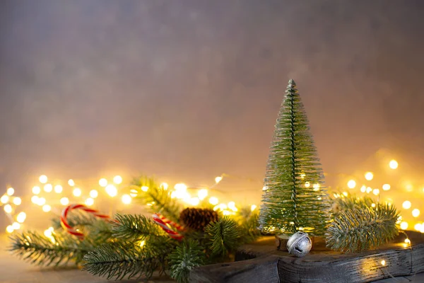 Choinka z gałązkami jodły, laski cukierki, dzwonki i lampki świąteczne na niebieskim tle.Christmas świąteczna karta z miejsca kopiowania. — Zdjęcie stockowe
