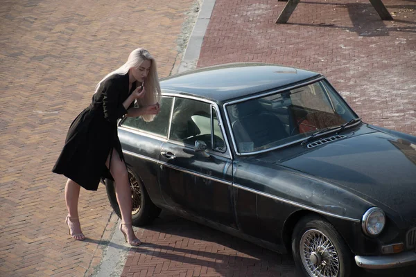 Ξανθό Κορίτσι Και Παλιά Μαύρο Αυτοκίνητο — Φωτογραφία Αρχείου