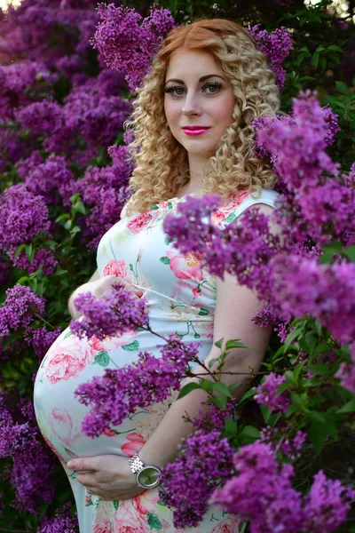 Zwanger meisje glimlachend in een bloeiende lente Park, het meisje is wal — Stockfoto