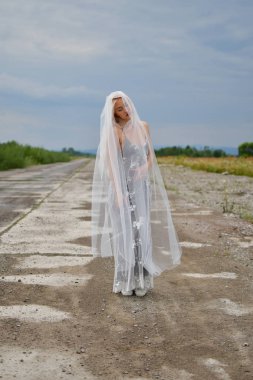 alanında eski bir havaalanının pistinde peçe ile sarışın