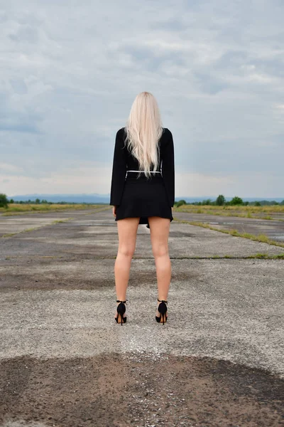 Sexy blonde in een mini rok op runway — Stockfoto