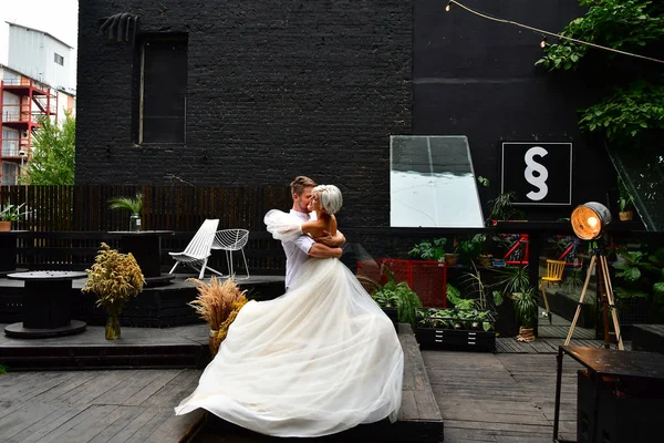 Glückliches junges Hochzeitspaar küsst und umarmt sich und tanzt Walzer — Stockfoto