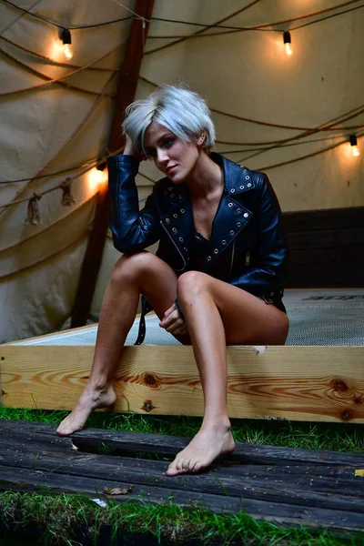 Sexy Blondine allein im Zelt mit Girlanden aus Romantik und Leder j — Stockfoto