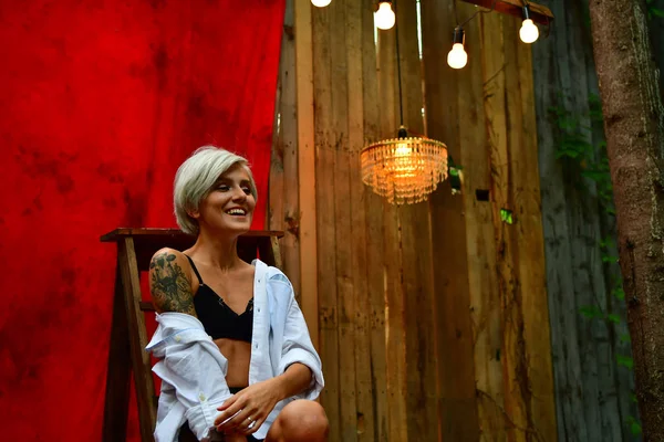 Bella ragazza con i capelli corti in posa davanti alla tenda rossa un — Foto Stock