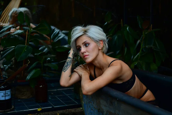 Beautiful short-haired girl with tattoo posing in bath. romance. — Stok fotoğraf