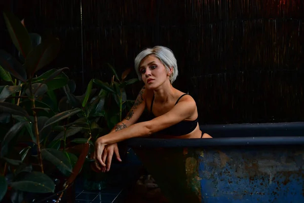 Schöne kurzhaarige Mädchen mit Tätowierung posiert im Bad. Romantik. — Stockfoto