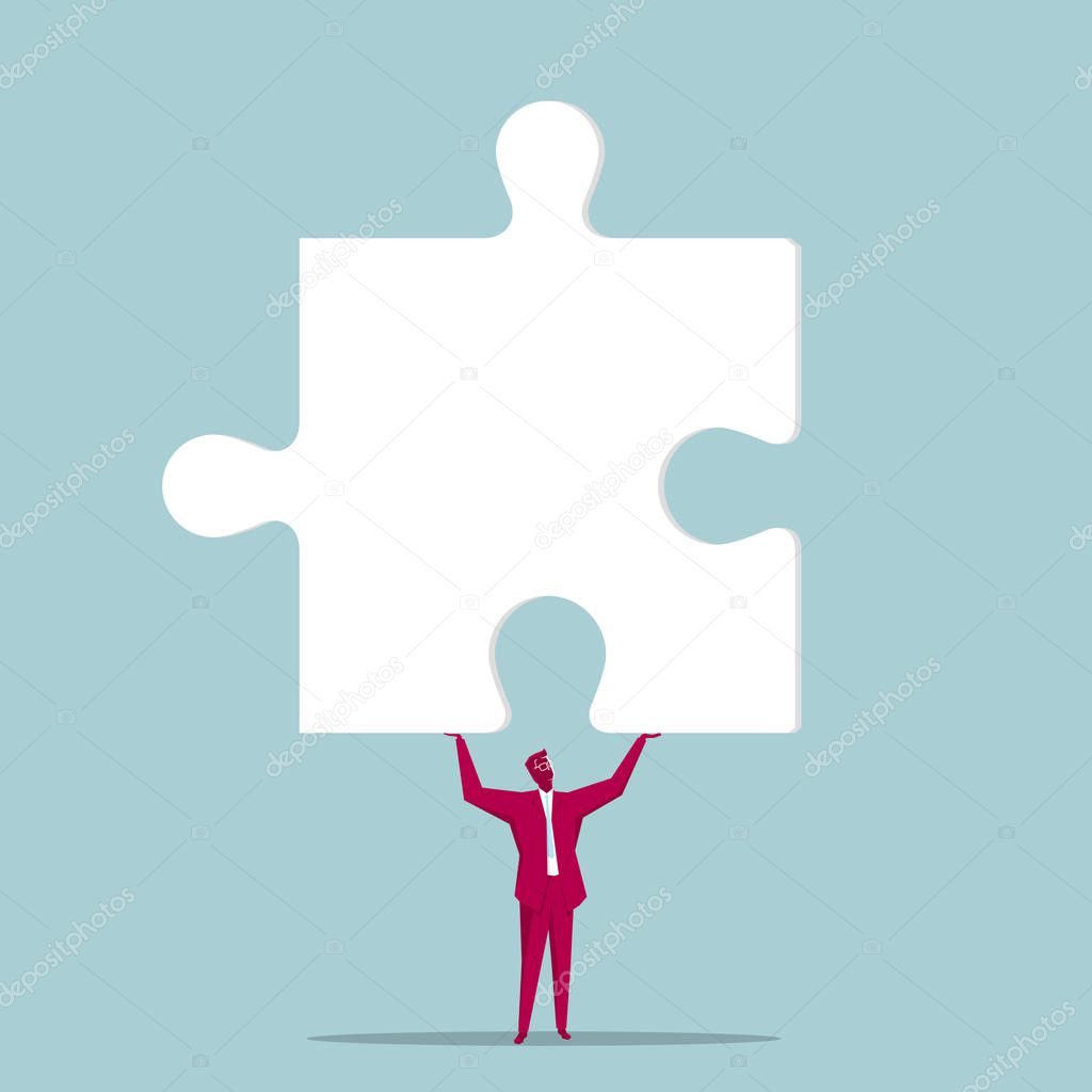 Businessman holds up the puzzle symbol. Isolated on blue background.