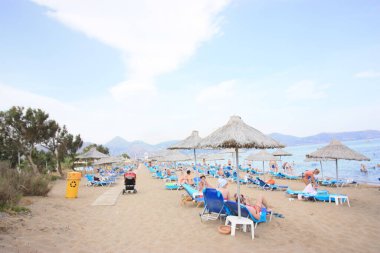 Girit 'te sahil yatakları ve plaj şemsiyeleri olan bir sahil.