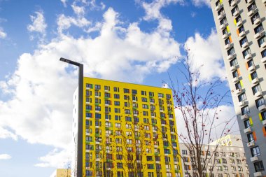 Mavi bir gökyüzü bulutlar arka plan ile modern bir yeni sarı ev.