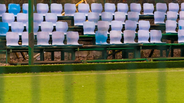 Pustych niebieskich i białych siedzeń w piłce nożnej lub w trawie stadionu piłkarskiego — Zdjęcie stockowe