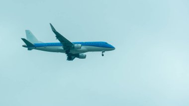 Mavi bir uçak uçan ve iniş için hazırlanıyor, açık iniş ile