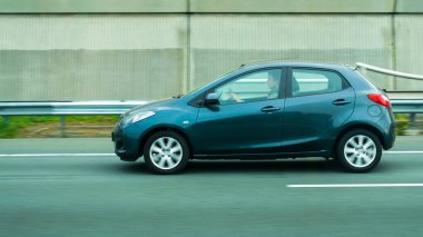 Yolda giden 5 koltuklu, r üzerinde dikkatli bir sürücü ile