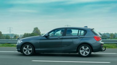 Yolda giden 5 koltuklu, r üzerinde dikkatli bir sürücü ile