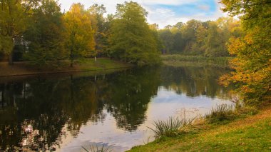 Bremen Almanya, parlak renkli yaprakları ile sonbahar ve su yansıması parkından görünümü