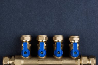 Pirinç manifold, Pex bağlantı parçaları ile dokulu koyu arka plan üzerinde küresel vanalar.