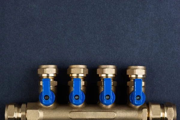 Pirinç manifold, Pex bağlantı parçaları ile dokulu koyu arka plan üzerinde küresel vanalar.