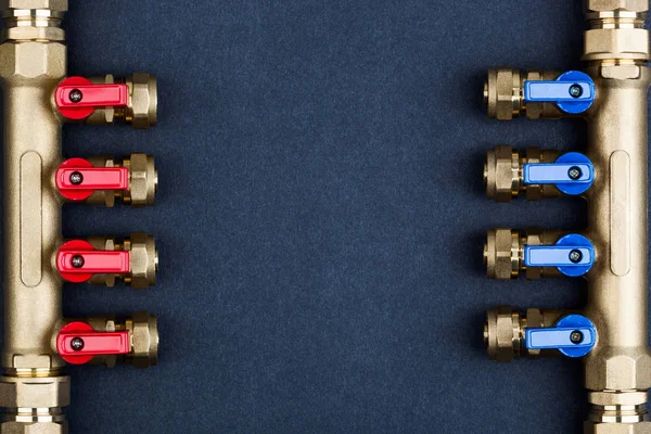 Brass manifold, PEX Fittings with ball valves on textured dark background.