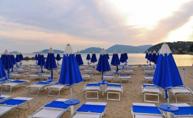 su küçük kasaba Kuzey İtalya Liguria Lerici çöl plaj ve günbatımı üzerinde renkli mavi şemsiye